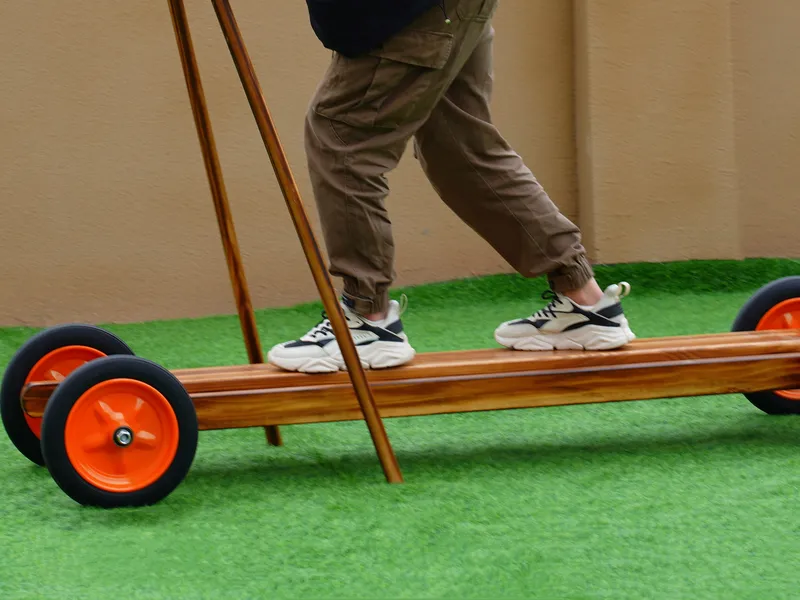 Children using charred wood rowing play set for balance development