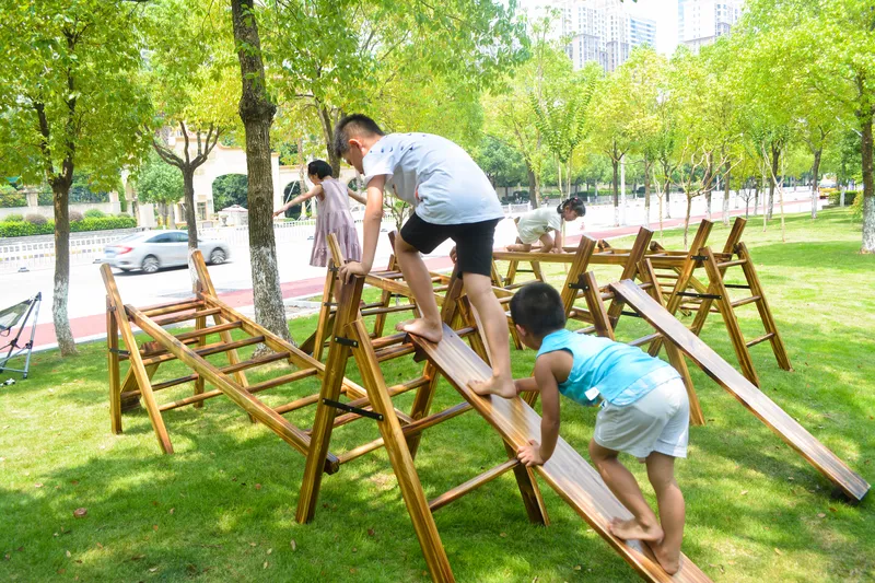 Children using outdoor agility ladder for athletic skills development