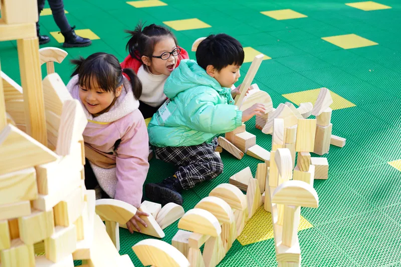 Anji play materials showing children deeply engaged in collaborative construction with wooden equipment