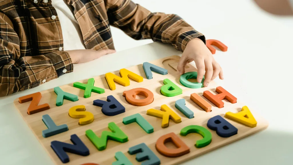 Pre K Activities for alphabet recognition using wooden letter toys with children engaged in learning