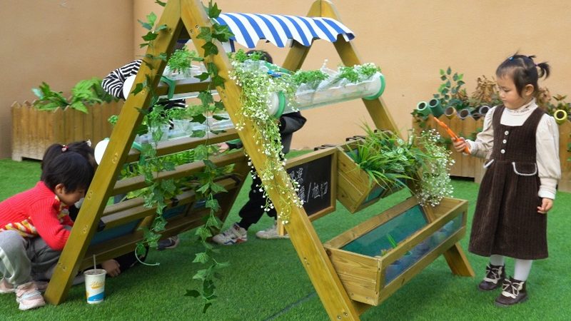 Children learning about plant growth and responsibility in Play Village gardening zone