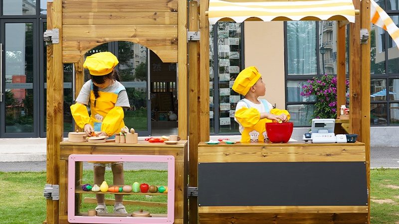 Children learning math and social skills in Play Village wooden restaurant area