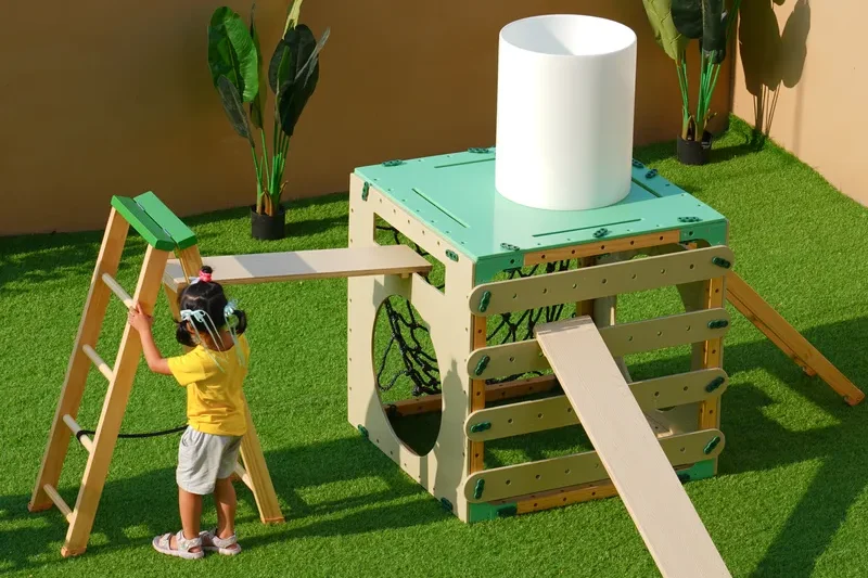 Children using anji play equipment to build challenging climbing structures demonstrating risk and problem solving