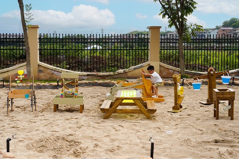 Anji play outdoor environment showing children with water, sand and natural materials for sensory play