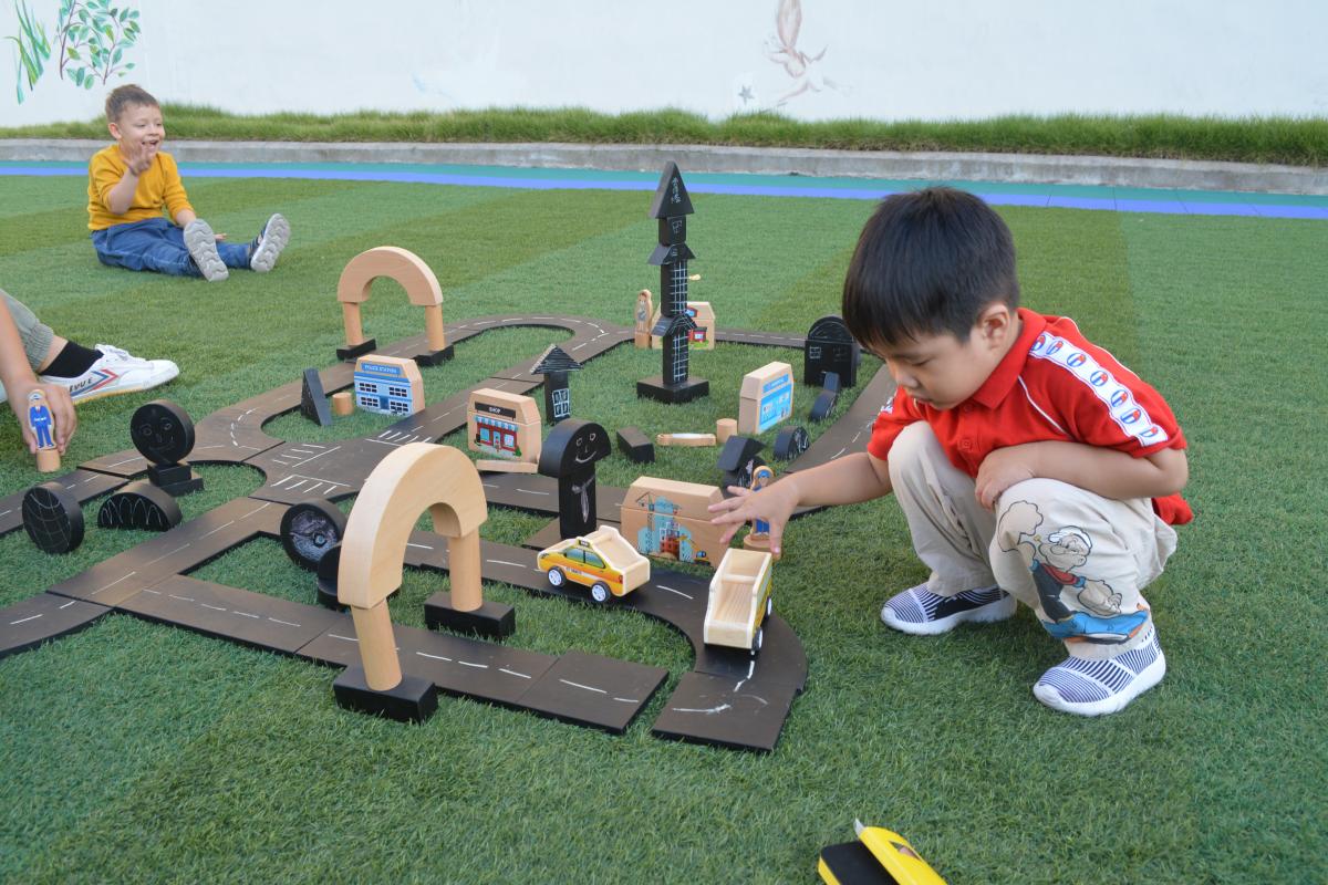 Associative play example with children sharing wooden construction materials