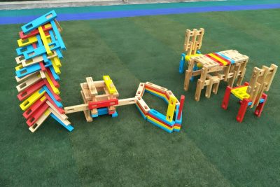 Colorful interlocking wooden construction blocks assembled into large outdoor structures