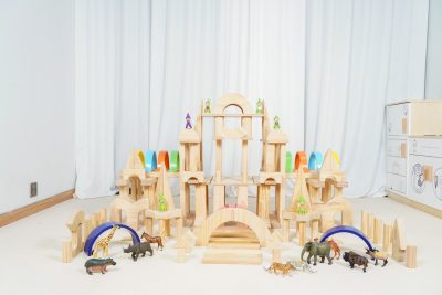 195-piece rainbow architectural wooden block set arranged as a large castle with natural pine blocks and colorful arches