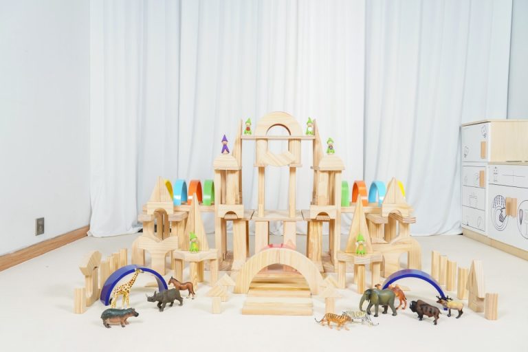 Rainbow architectural wooden block set arranged as a large preschool castle