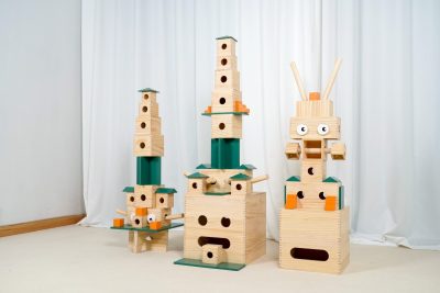 Modular pinewood hollow blocks arranged as robots towers and large cube structures