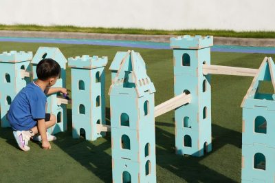 Colored wooden ball rolling along a track between modular castle towers