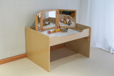 Children exploring translucent numbers on an illuminated sensory light table with a large acrylic mirror