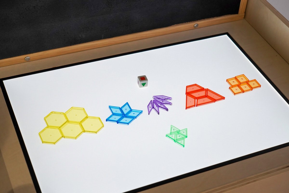 Sensory Light Table Guide: 15 Activities and Setup Tips 2 Translucent colored materials arranged on an illuminated classroom table