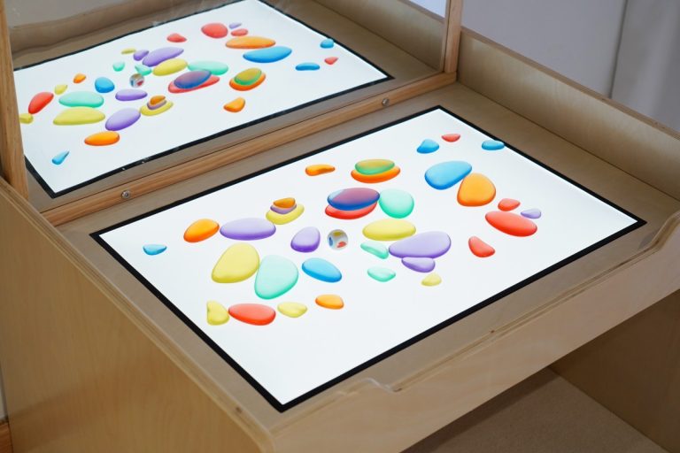 Sensory Light Table Guide: 15 Activities and Setup Tips 7 Colorful translucent discs and transparent pebbles for sorting counting and sensory patterns