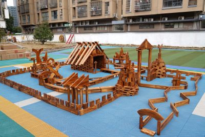 866-piece outdoor construction blocks play set arranged into a large carbonized wooden preschool building environment
