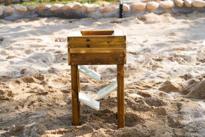 outdoor wooden sand flow station with tray chutes for preschool gravity play
