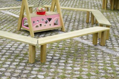 outdoor bench for kids with six modular wooden benches arranged around a preschool activity area