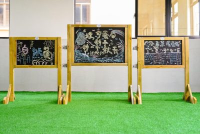 outdoor chalkboard for kids with one large and two small freestanding wooden boards