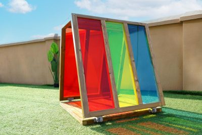 outdoor art house with rainbow acrylic panels for kids mark-making and color exploration