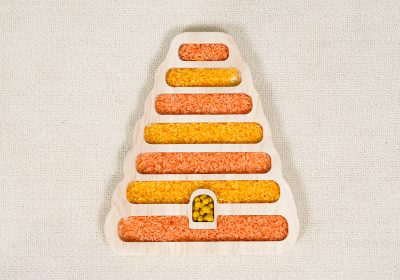 beehive sensory tray made from rubberwood with orange and yellow rice in layered compartments