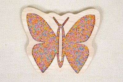 butterfly sensory tray made from rubberwood with symmetrical wing compartments filled with colorful sensory rice