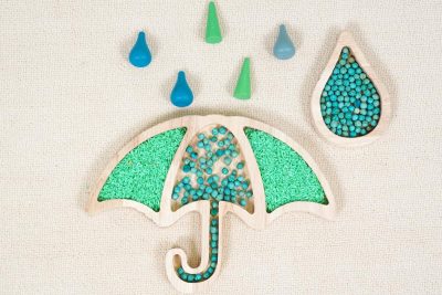 umbrella sensory tray made from rubberwood with green rice and blue weather themed loose parts