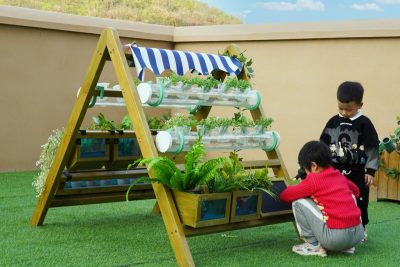 wooden outdoor garden center for preschool with multiple planting areas in a school garden